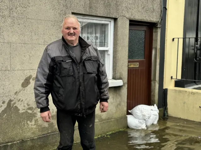 Paul Brannigan standing outside his flooded house in Camlough