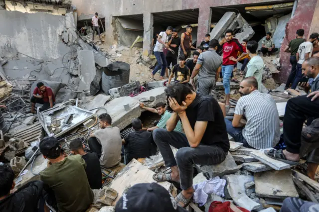 Civil defense teams conduct operations with the help of civilians after an Israeli airstrike caused destruction in Rafah