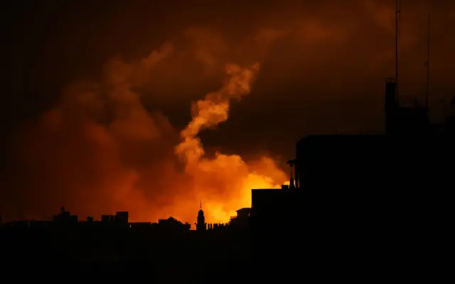 A lighting flare, fired by Israel forces in the sky, is viewed in the northwest of Gaza on October 31, 2023.