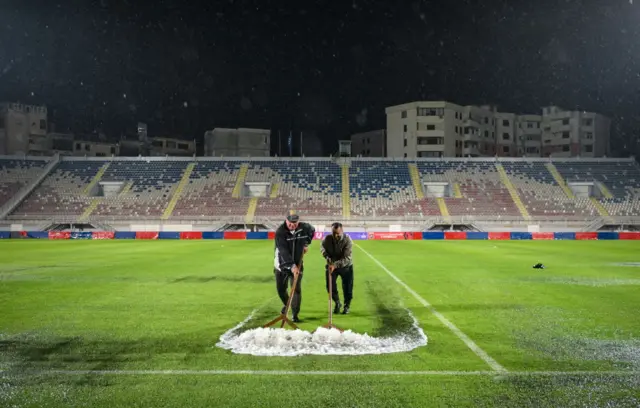 Ground staff clear the pitch of rain