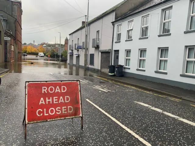 Sign that reads "ROAD AHEAD CLOSED"