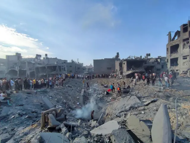 Palestinians search for casualties in a crater