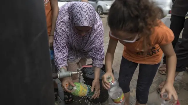 People collecting water from a tap in Khan Younis