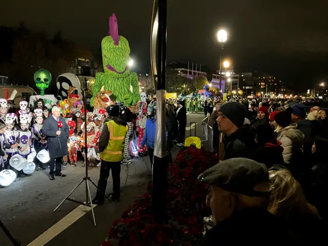 Shows BBC Newsline reporter Keiron Tourish surrounded by children in fancy dress