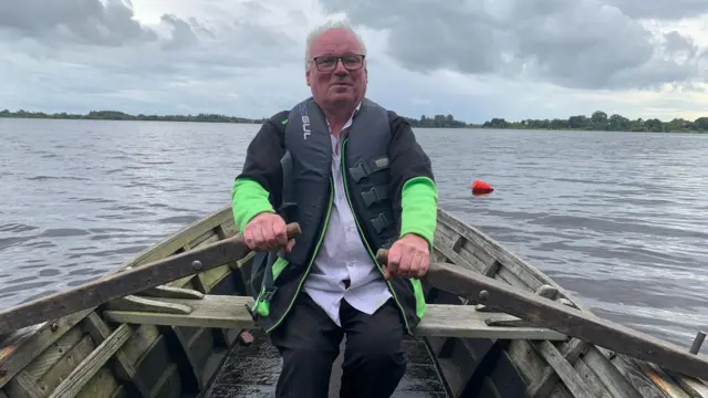 Pat Hughes rowing a cot on Lough Neagh