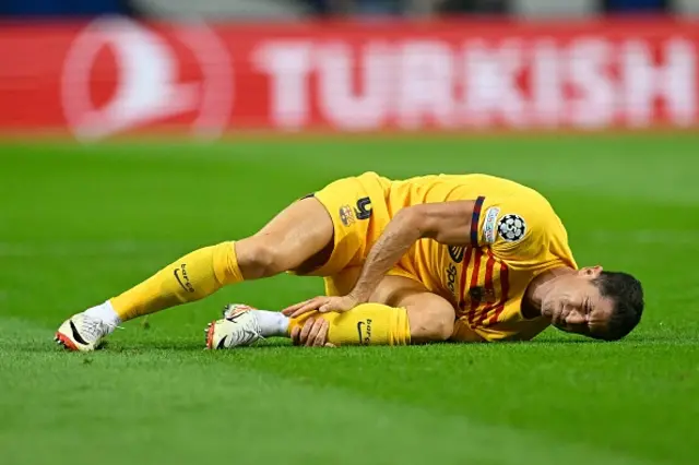 Robert Lewandowski lies on the pitch after a fall