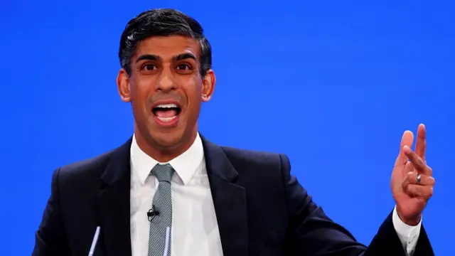 Rishi Sunak gestures as he speaks at conference