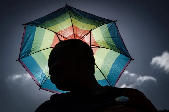 A member of the South African Lesbian, Gay, Bisexual and Transgender and Intersex (LGBTI) community holds an umbrella in the rainbow flag colours takes part in the annual Gay Pride Parade, as part of the Durban Pride Festival, on June 29, 2019 in Durban.