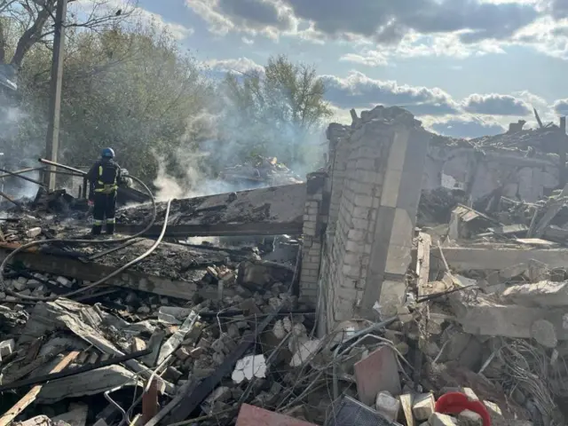 A firefighter sprays water on the bombed cafe in Hroza