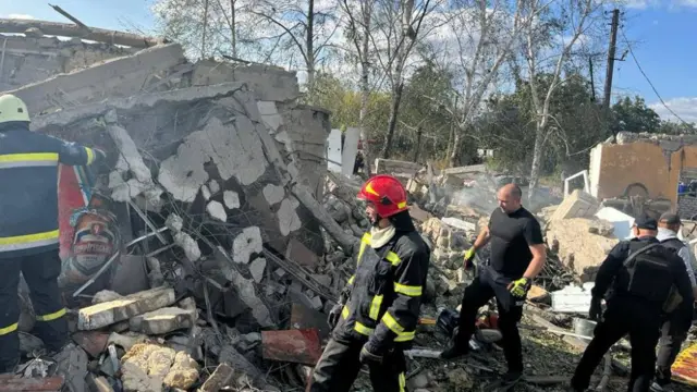 Rescue workers pick through the debris in Hroza