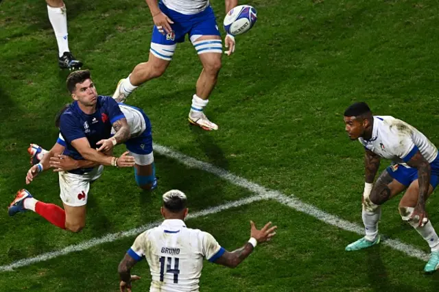 France's fly-half Matthieu Jalibert passes the ball as he is tackled