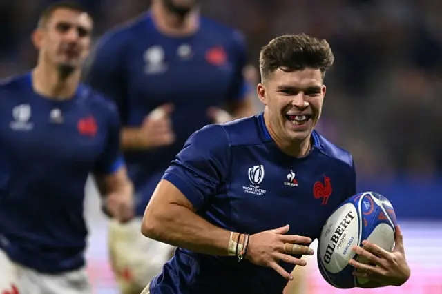 France's fly-half Matthieu Jalibert smiles as he runs to score