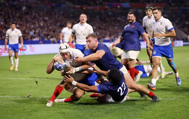 Manuel Zuliani of Italy scores as French players try to tackle him