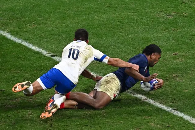 France's hooker Peato Mauvaka (R) dives over the line