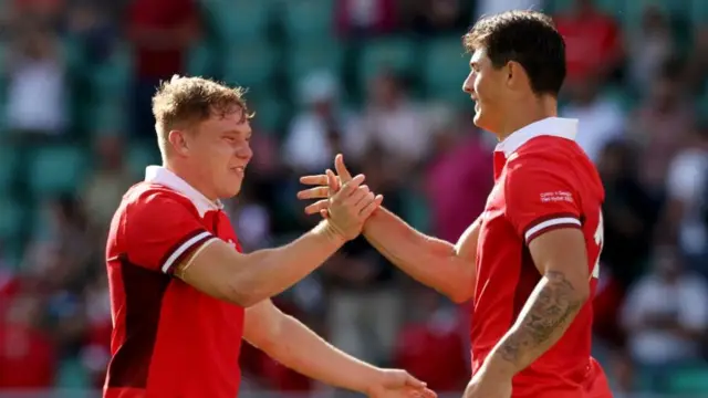 Sam Costelow shakes hands with Louis Rees-Zammit