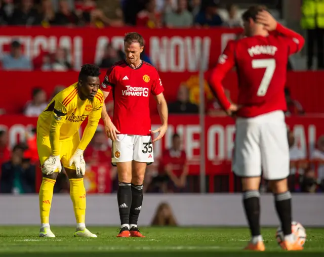 Onana stands on his haunches as Mount and Evans stand stunned.