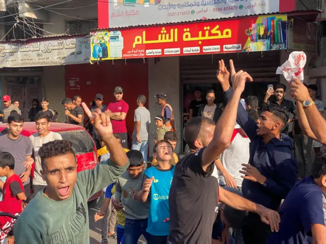 Palestinians celebrate in the Gaza Strip after dozens of Hamas gunmen appeared to have infiltrated southern Israel