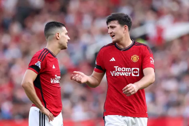 Maguire and Dalot gesticulate in an animated conversation.