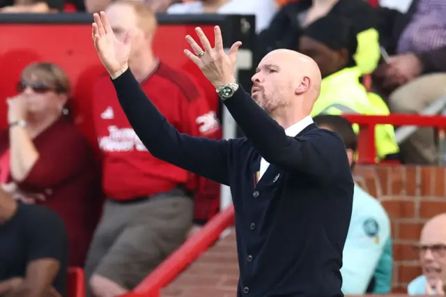 Ten Hag throws his hands in the air in frustration.