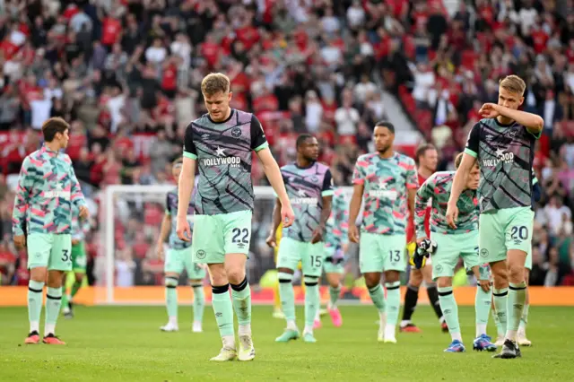 Brentford players trudge to the corner of Old Trafford to thank the away fans.