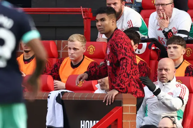 Casemiro stares at Ten Hag as he takes his seat on the bench.