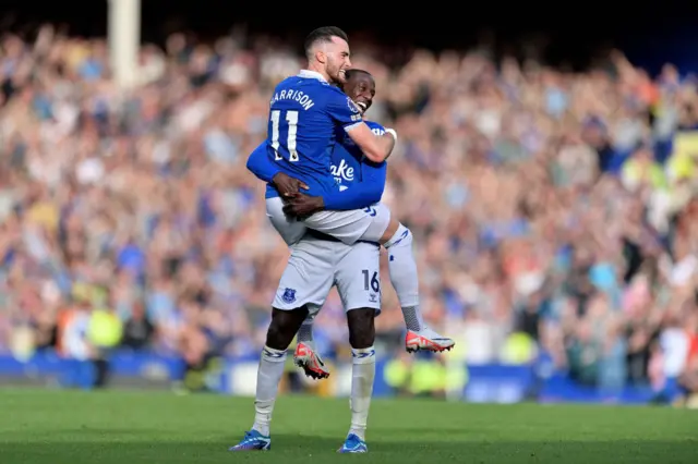 Harrison jumps into the arms of Doucoure in celebration of his goal.