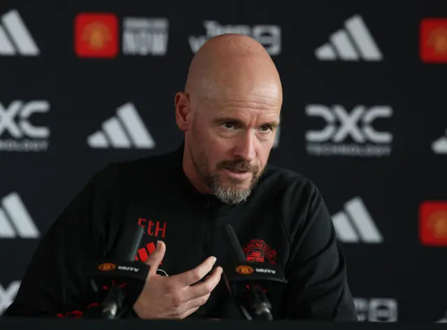 Ten Hag gestures with his right hand while explaining a point to the press.