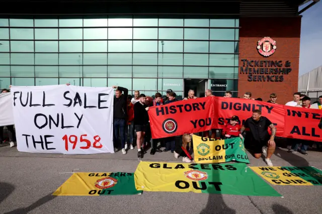 United fans hold banners with messages against the Glazer ownership.