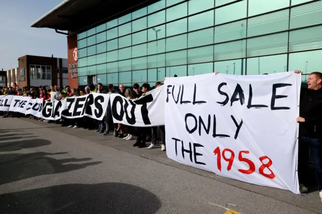 Fans hold banners against the Glazer ownership and toward a full sale of the club.