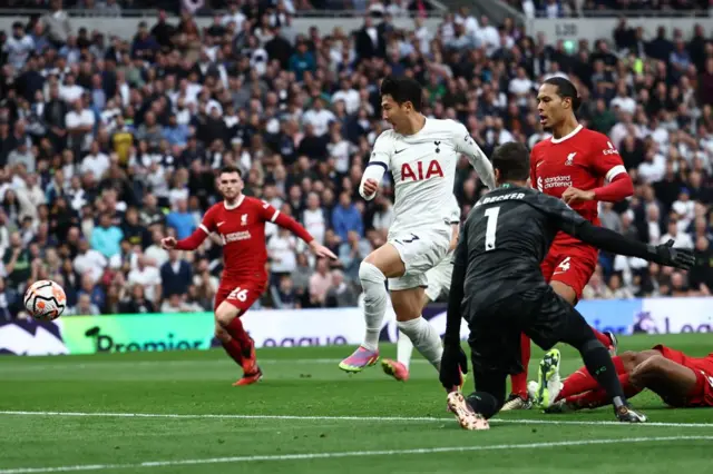 Son shoots towards goal as Liverpool's keeper and defence watch on.