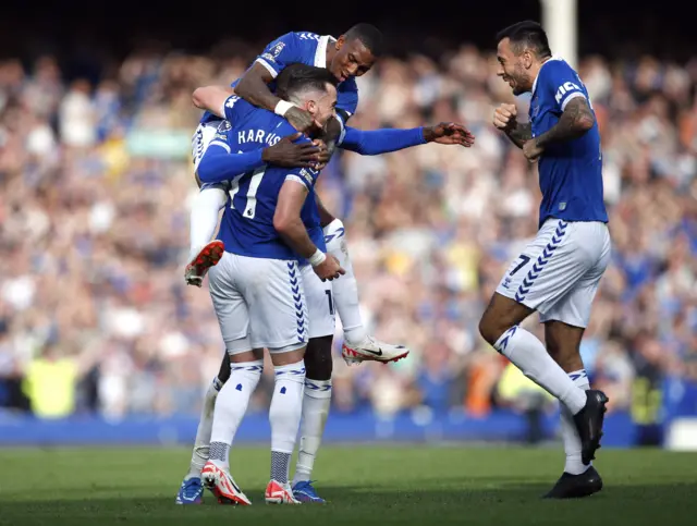 Everton players pile on Harrison after he scored his first goal for the club.