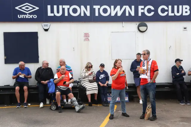 Luton fans congregate together outside the home entrance of the ground.