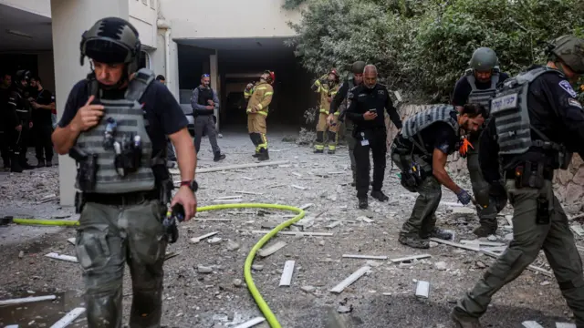 Israeli police and security officials clear up debris