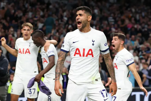 Romero screams in delight as Spurs players gather to celebrate behind him.