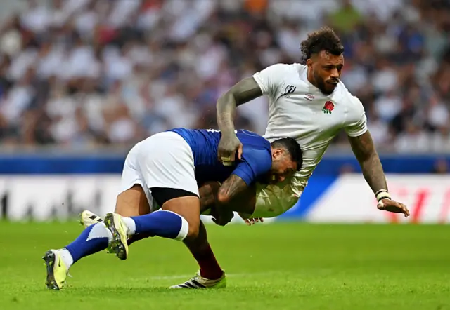 Courtney Lawes of England is tackled by Lima Sopoaga