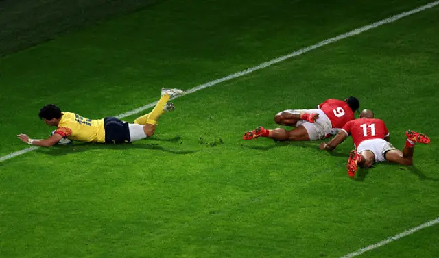 Marius Simionescu of Romania dives over the line leaving Tongan players behind
