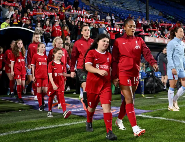 The captains lead the teams out onto the pitch.