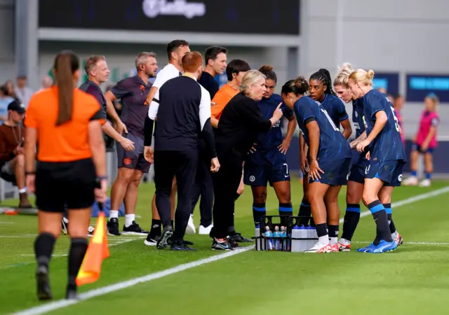 Hayes does a tactical brief with her players on the touchline.