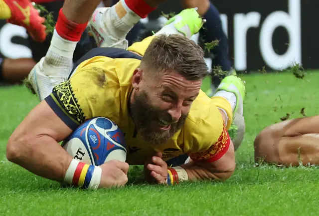 Romania's scrum-half Florin Surugiu dives across the line
