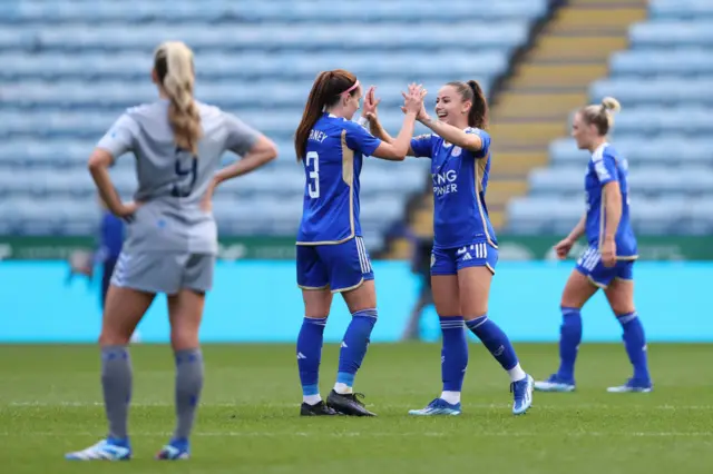 Leicester players high five at full time, Everton players stand around them forlornly.