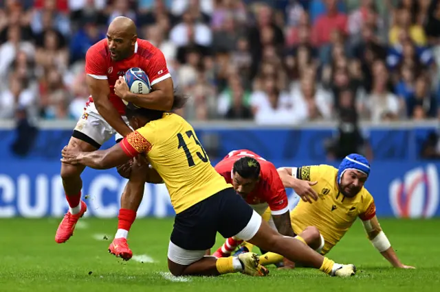 Afusipa Taumoepeau of Tonga is tackled by Tevita Manumua