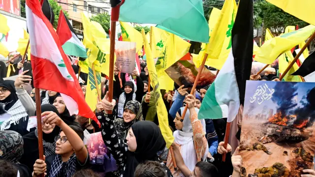 Supporters of Hezbollah hold Palestinian and Hezbollah flags in Beirut, Lebanon,