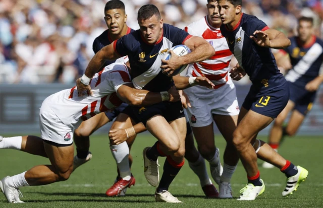 Emiliano Boffeli runs with the ball while being tackled