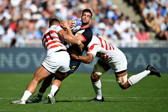 Juan Cruz Mallia of Argentina is tackled by Siosaia Fifita and Michael Leitch