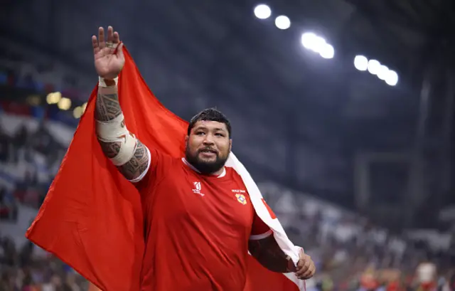 Ben Tameifuna of Tonga reacts with the Tongan flag around him