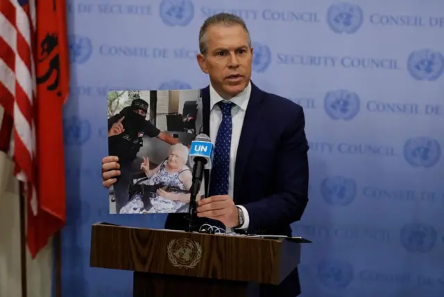 Israeli Ambassador to the United Nations, Gilad Erdan, holds up a photograph of an Israeli woman holding a Hamas machine gun, as he speaks to the media before Security Council consultations at United Nations headquarters in New York, New York, USA, 08 October 2023