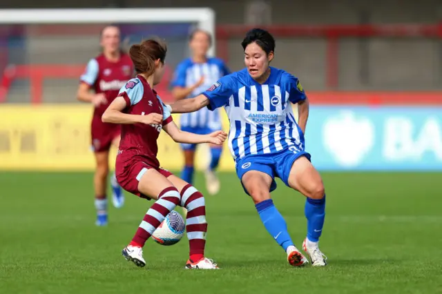 Geum-min tries to dribble past a West Ham player in the midfield.