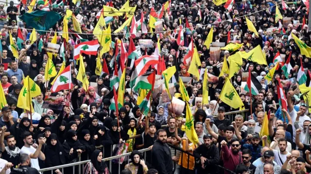 Supporters of Hezbollah hold Palestinian and Hezbollah flags during a rally in Beirut