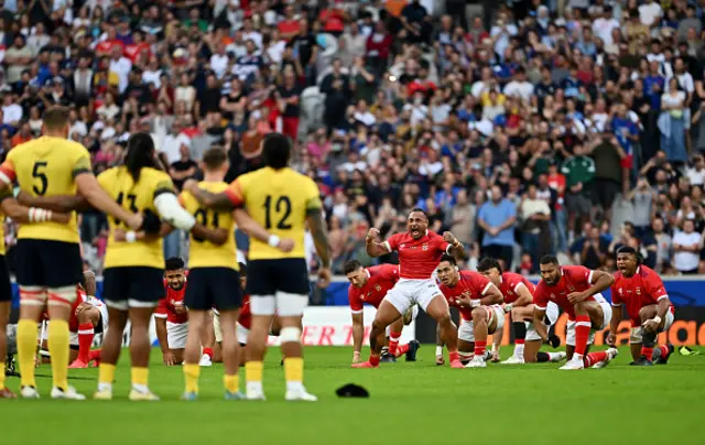 The players of Romania watch on as the players of Tonga perform the Sipi Tau