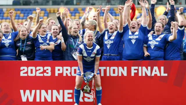 Barrow captain Jodie Litherland lifts the promotion final trophy with her teammates